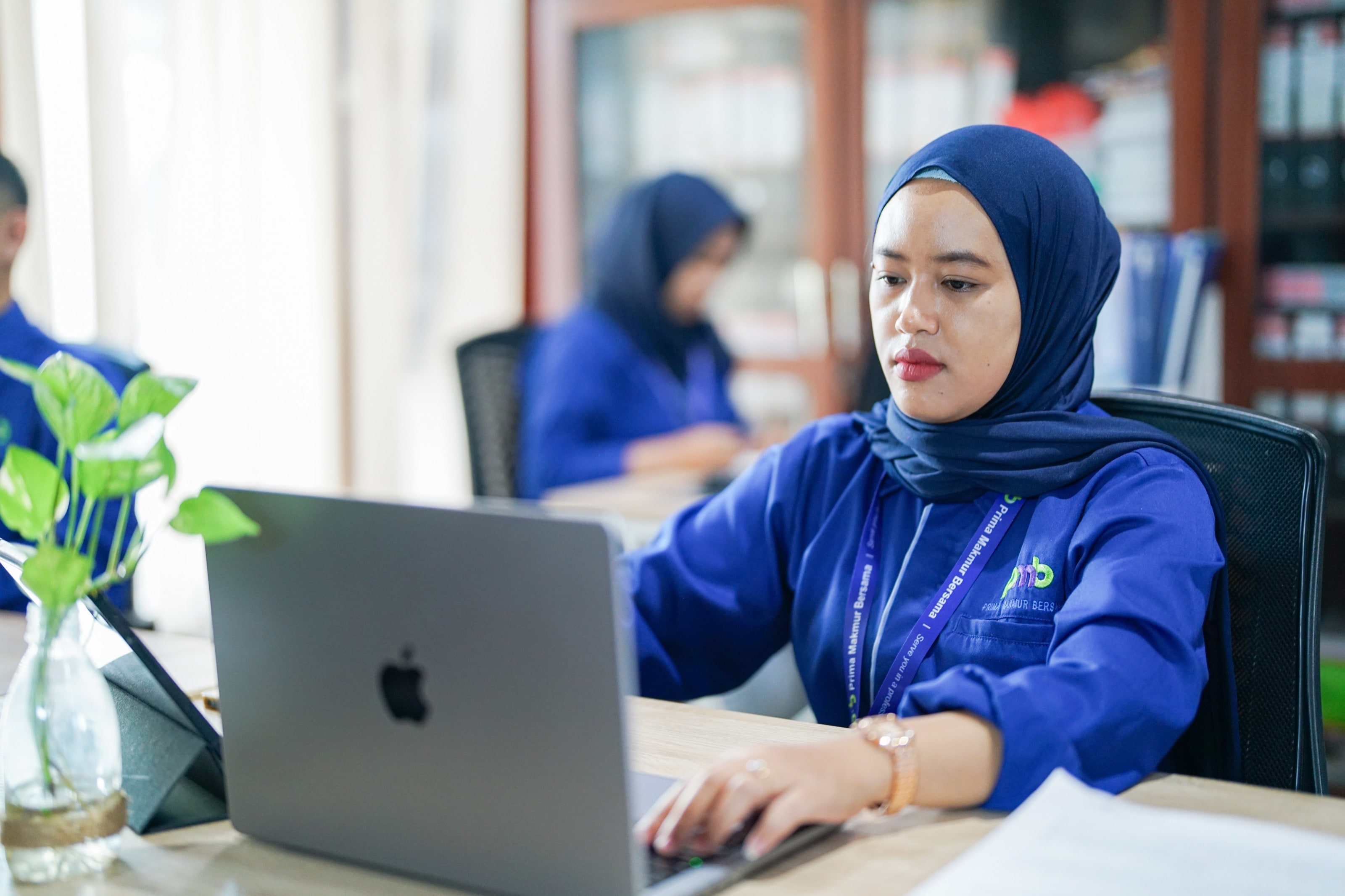 A PMB staff member working at a laptop in the office