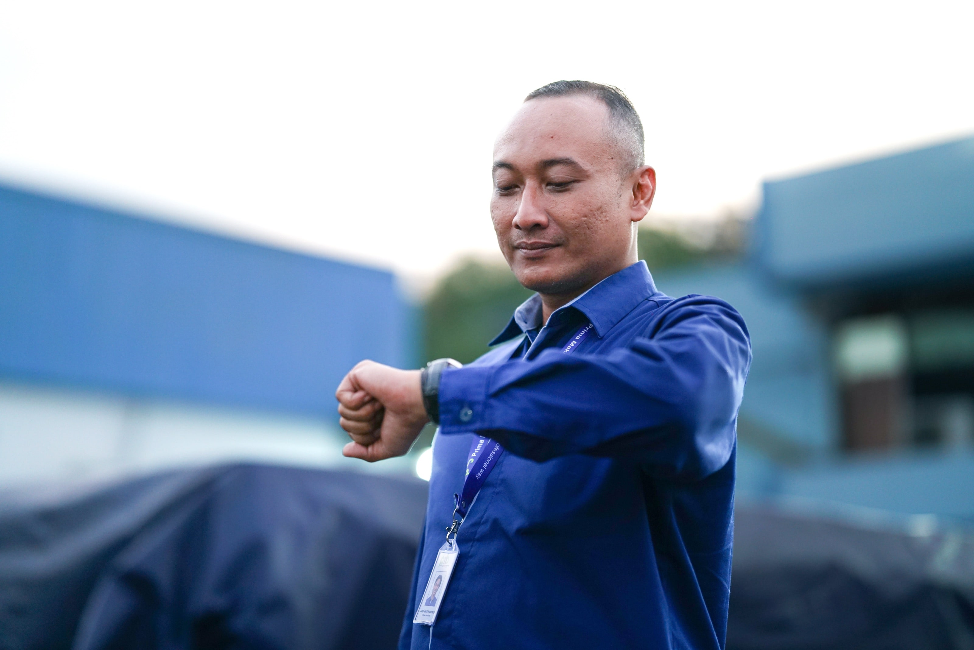 A PMB supervisor checking his watch at a partner facility