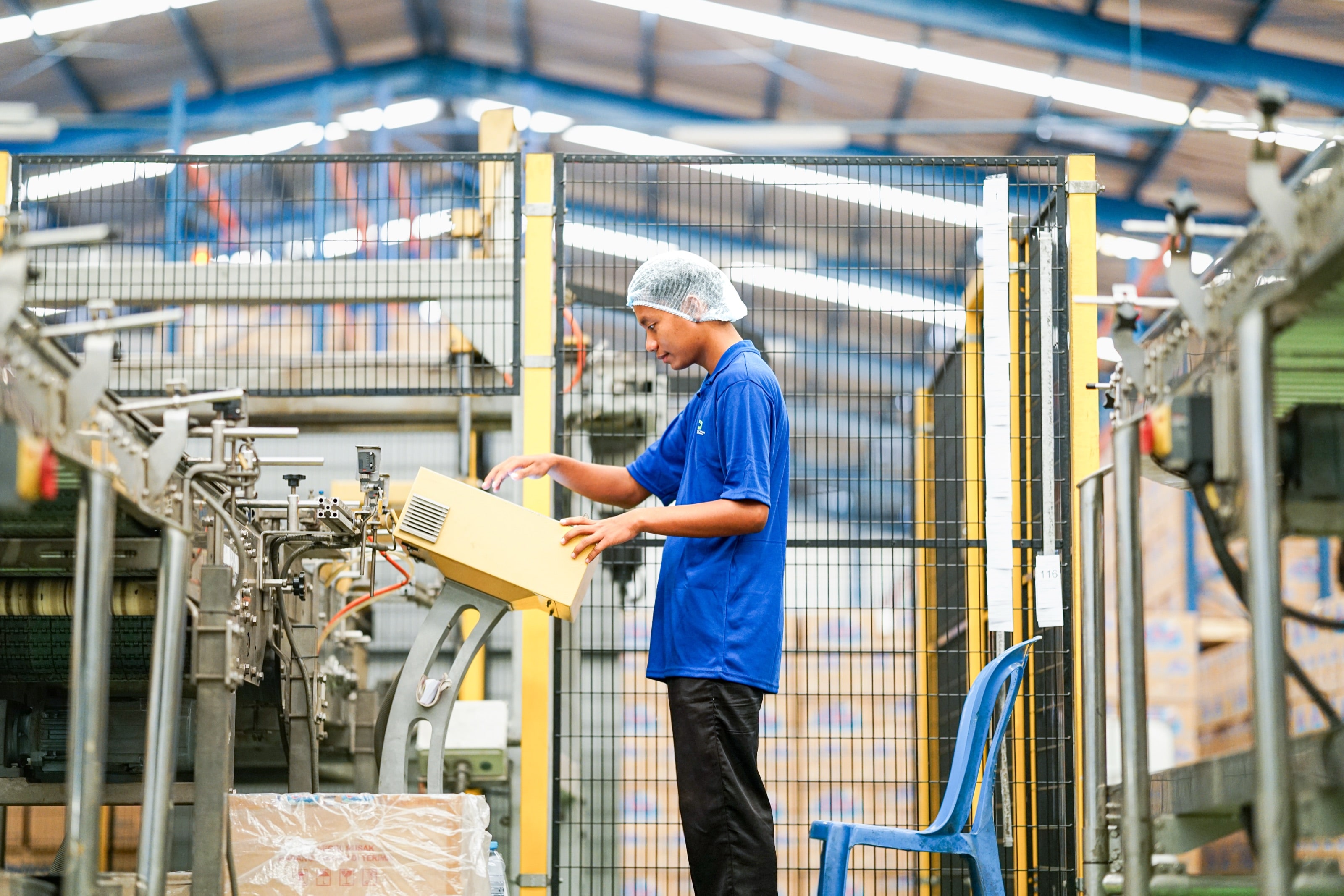 Tenaga kerja PMB menangani kardus di mesin pengemasan